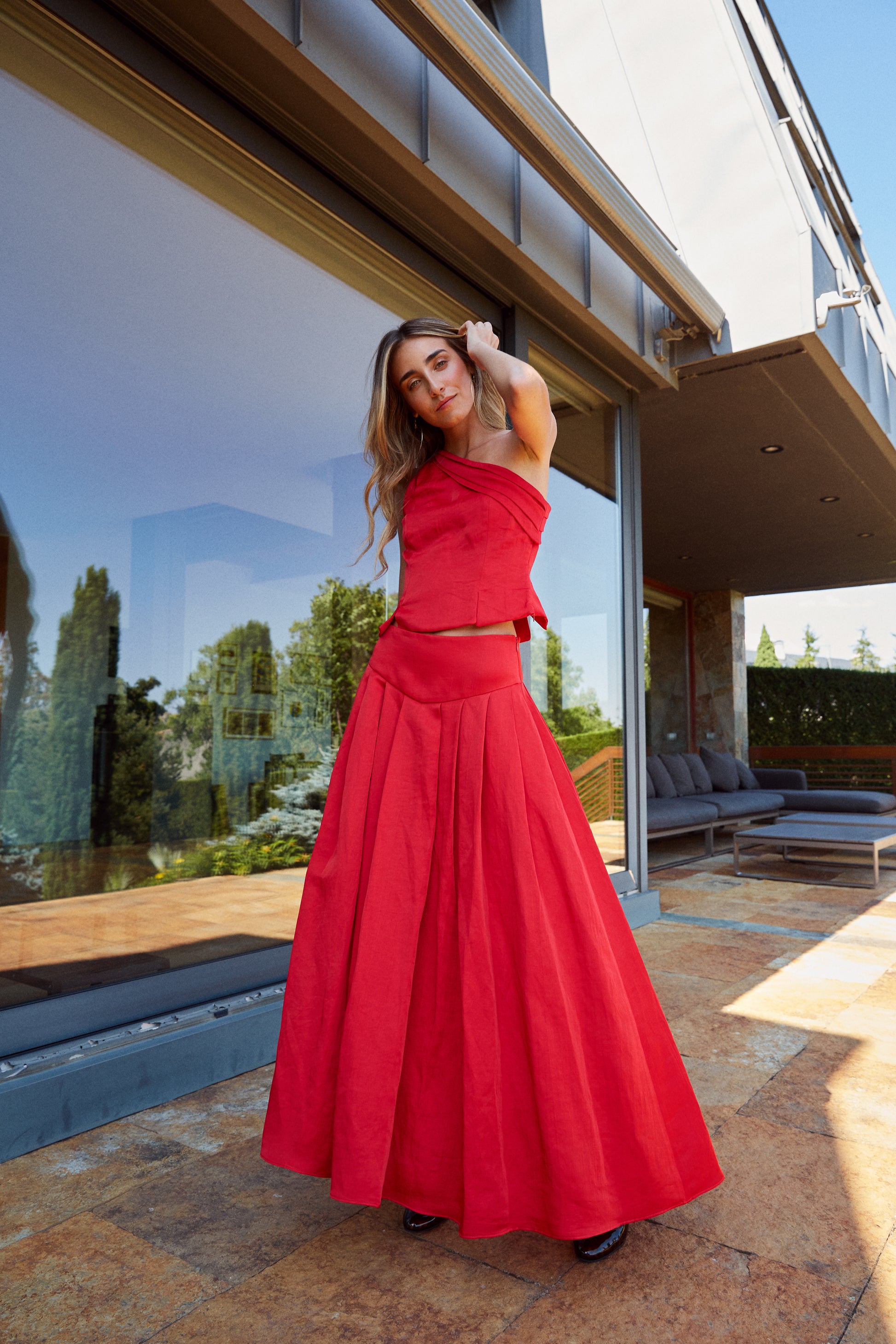 Falda larga roja con canesú en pico y tablas, vista frontal, ideal para eventos elegantes.