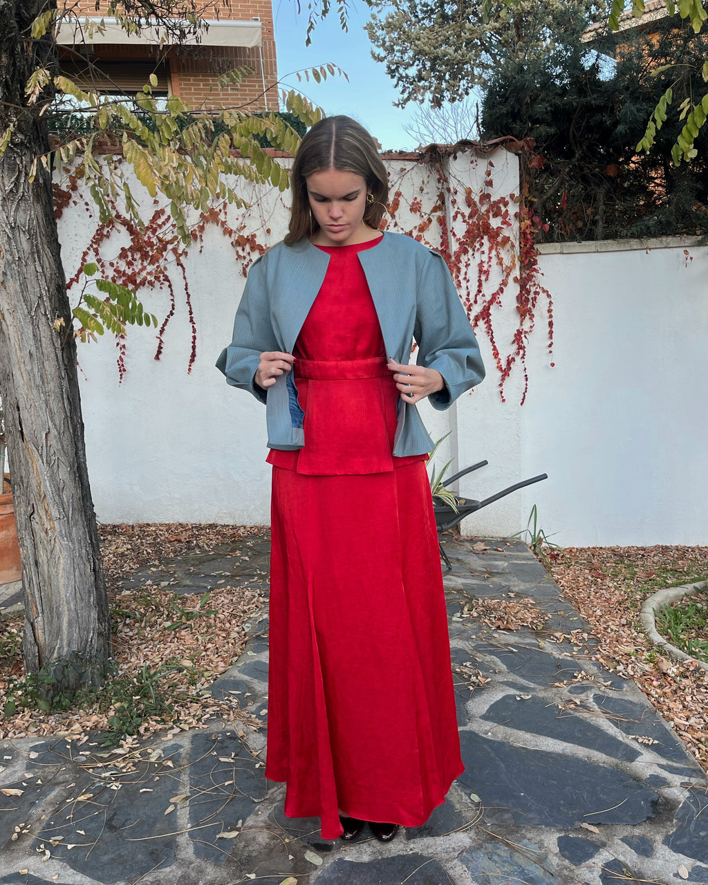 Detalle del forro azul petróleo y exterior de la chaqueta azul con rayas a tono; diseño elegante en jardín.