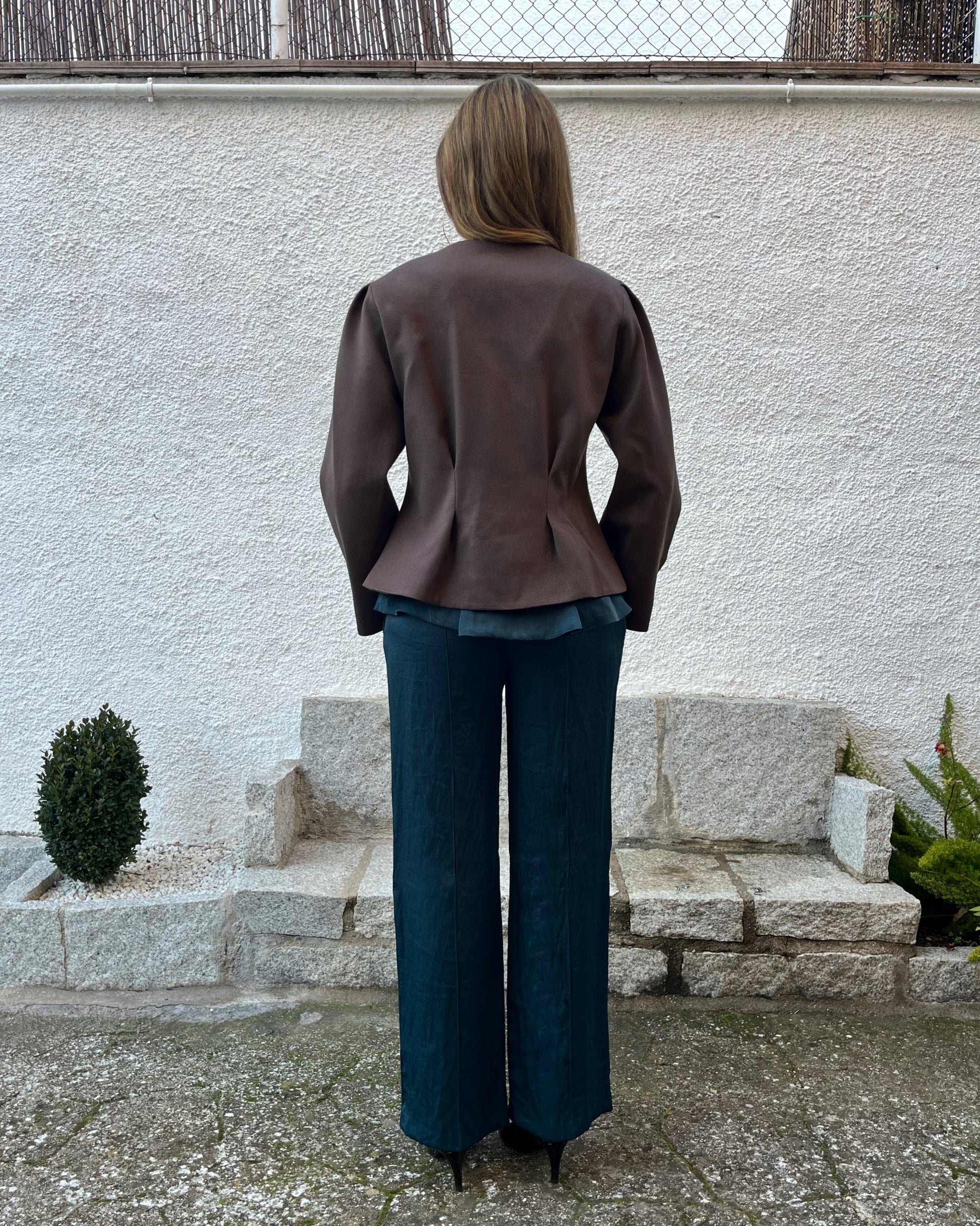 Chaqueta marrón de mujer con textura de lunares y pliegues entallados en la espalda; estilo elegante en jardín, colección Historia de un sastre.