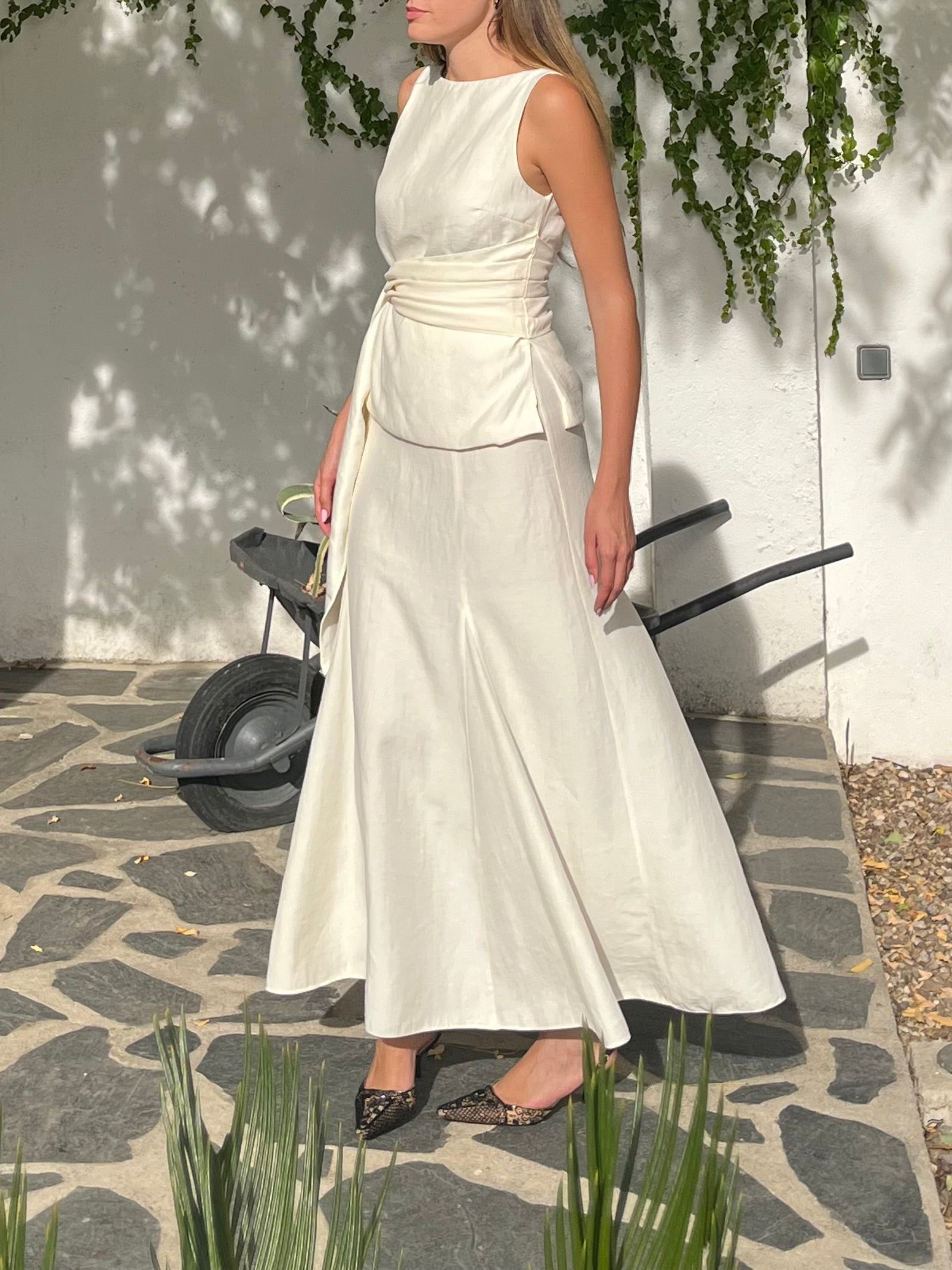 Conjunto blanco crudo de top con lazo y falda de godets en movimiento, un look fluido y sofisticado ideal para bodas y prebodas
