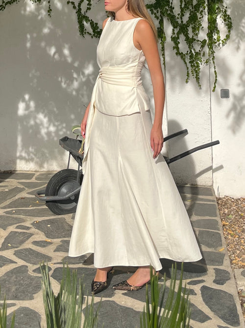 Conjunto blanco crudo de top con lazo y falda de godets en movimiento, un look fluido y sofisticado ideal para bodas y prebodas