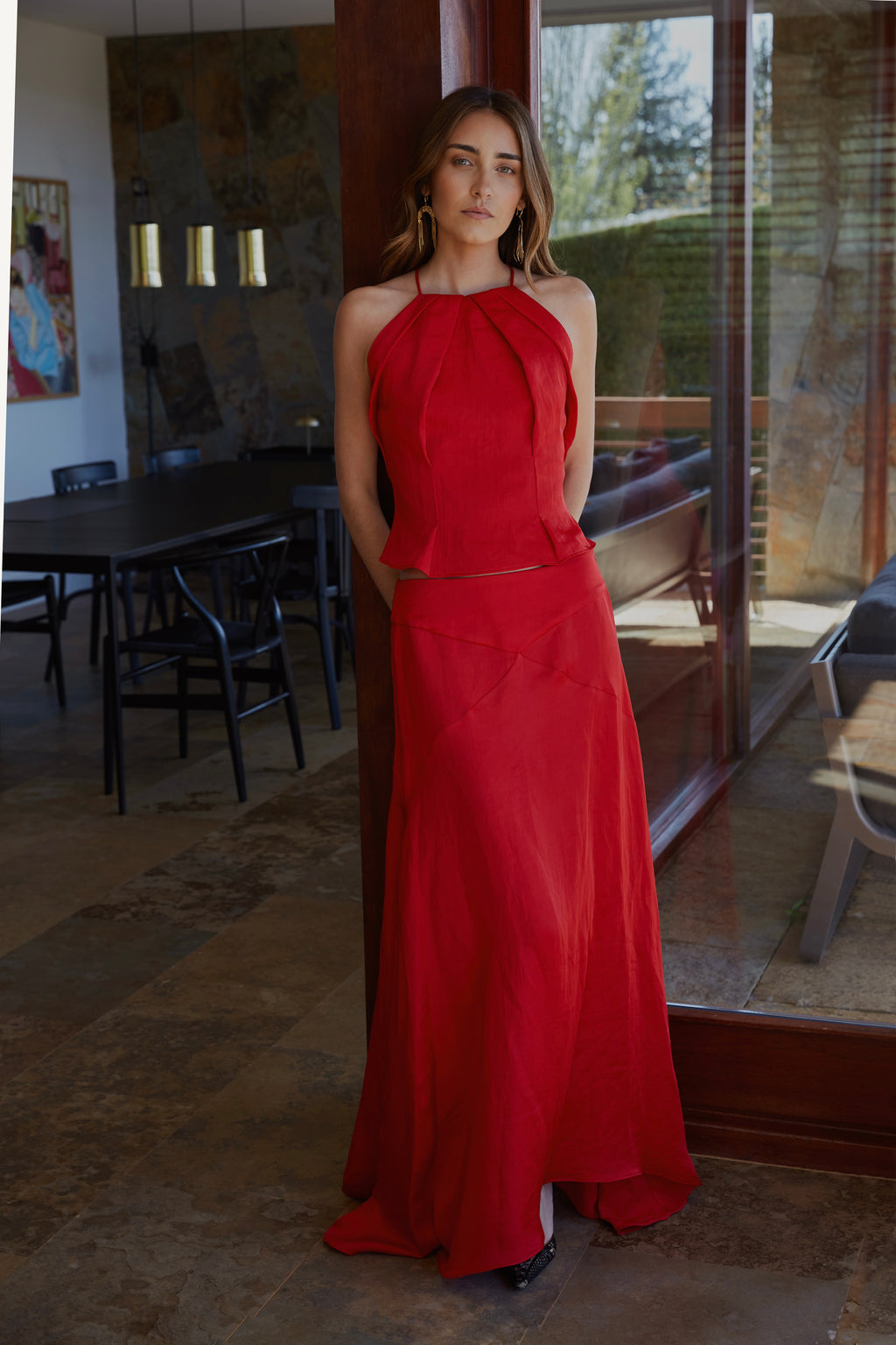 Look rojo elegante de mujer con top halter plisado y falda Marta larga fluida; conjunto ideal para boda o evento.