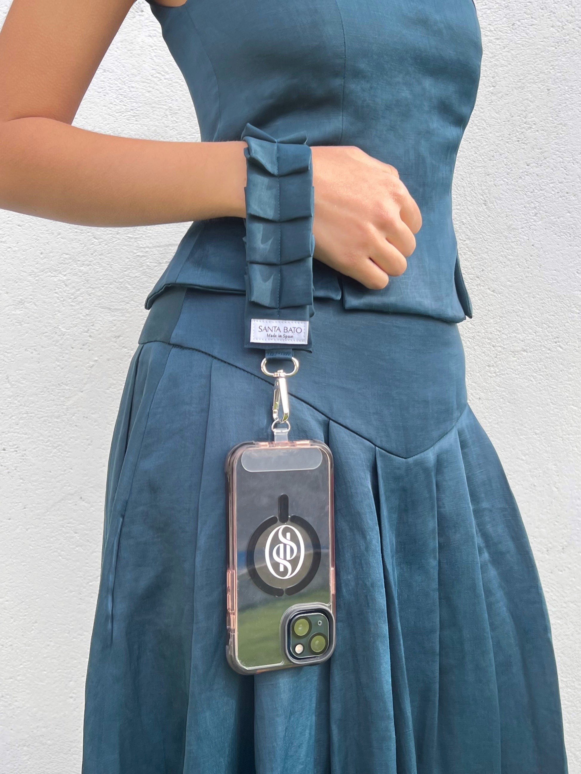 Mujer sujetando correa azul plisada con conjunto elegante, accesorio de moda para eventos y looks de invitada