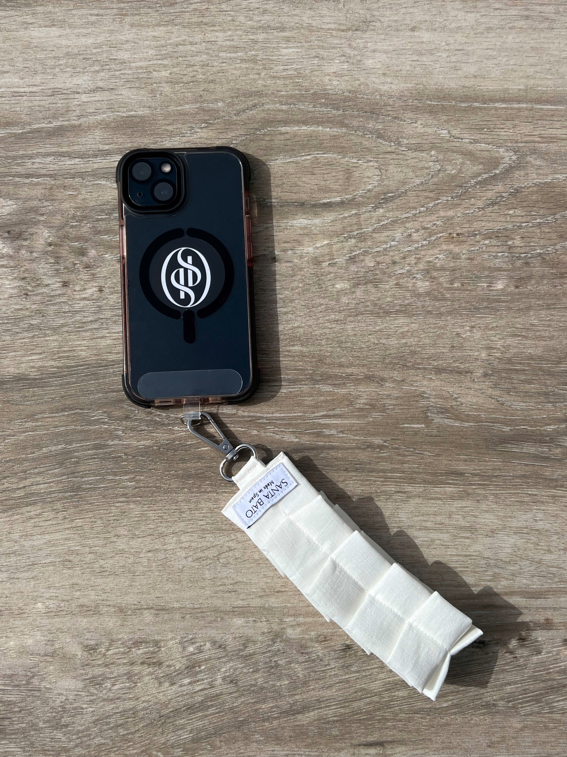 Teléfono con correa blanca plisada y aplique plateado, accesorio elegante de moda española