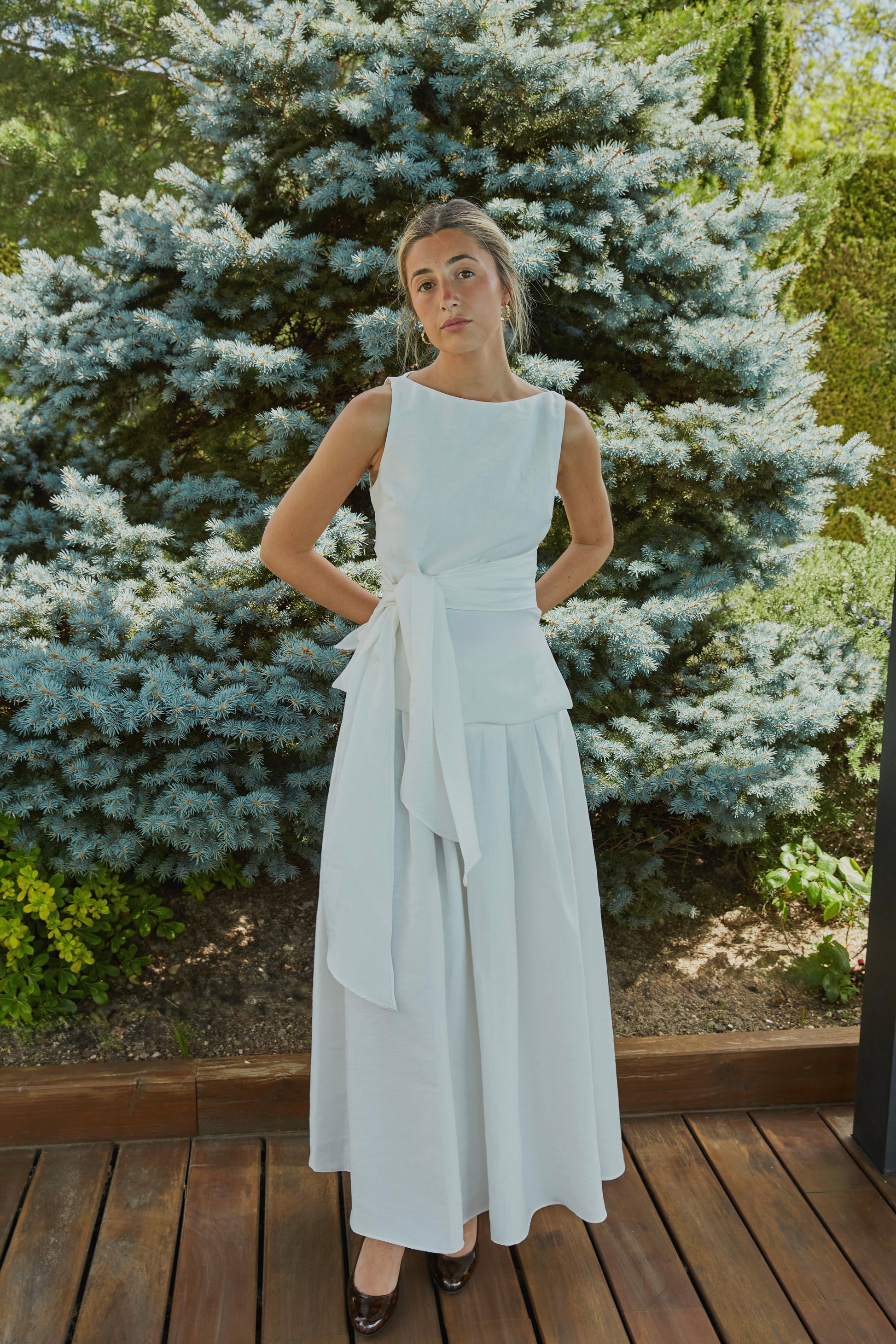 Conjunto de falda de tablas con top de lazo blanco, outfit de fiesta femenino y elegante.