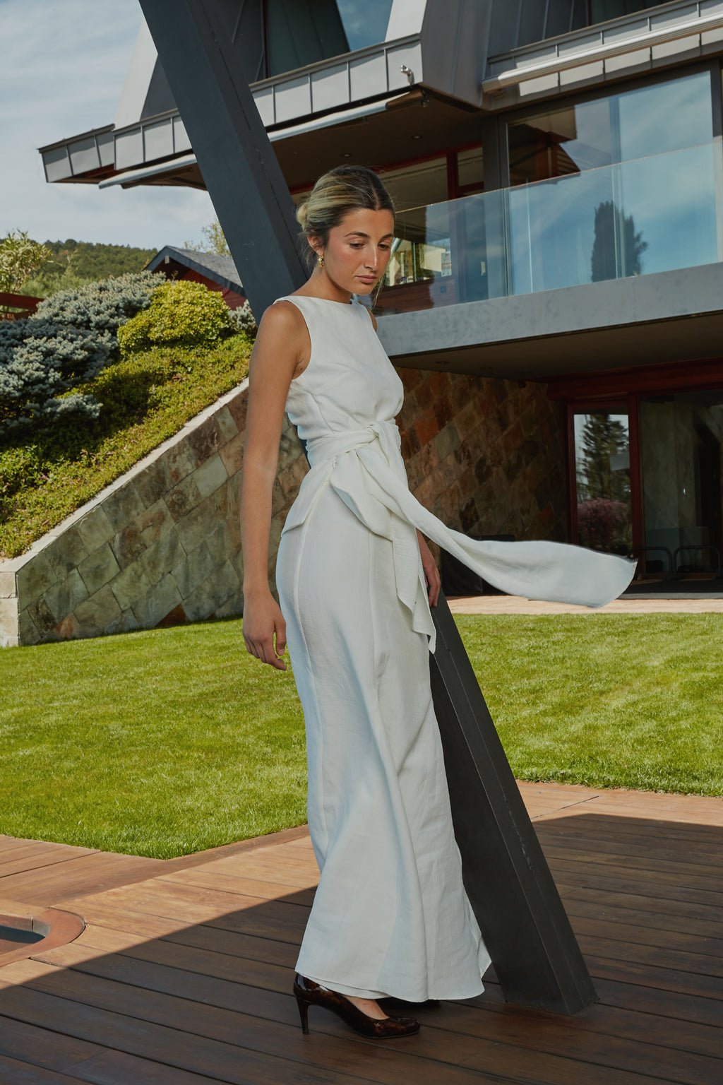 Look elegante con top blanco con  lazo en cintura, vista lateral, ideal para eventos.