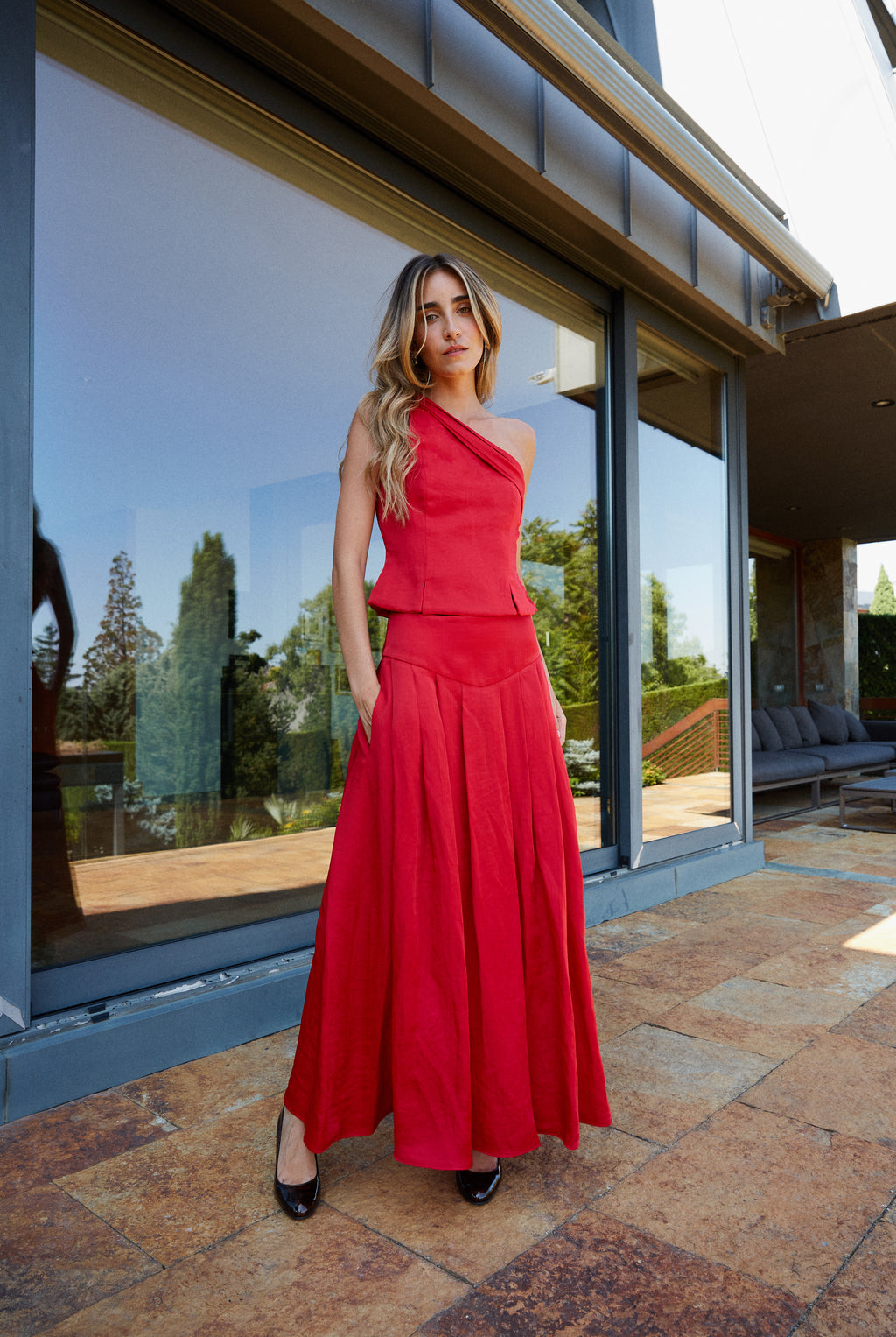 Falda con volumen y top asimétrico rojo, conjunto elegante para celebraciones y bodas.