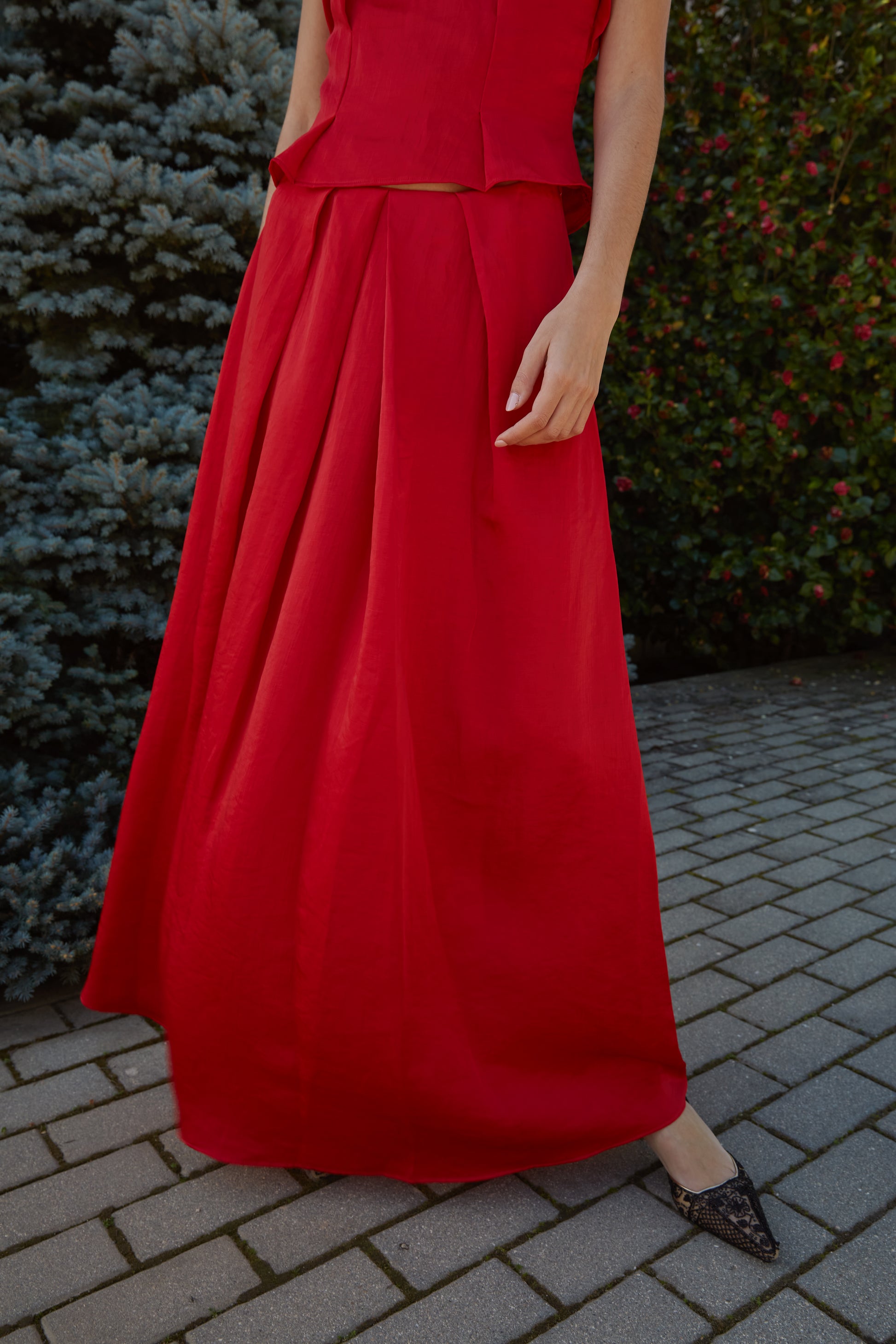 Falda larga rojo elegante de mujer con tiro alto y caída estructurada, diseño favorecedor ideal para invitada; vista frontal.