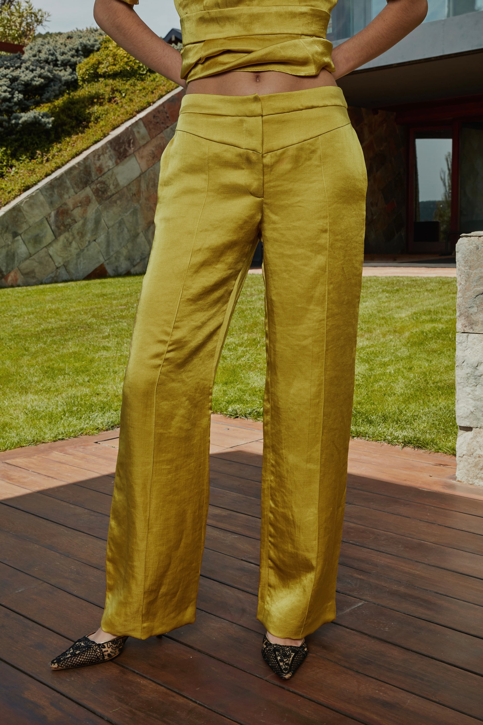 Pantalón color aceite amarillo verde dorado con canesú en pico y pernera ancha, vista frontal completa.
