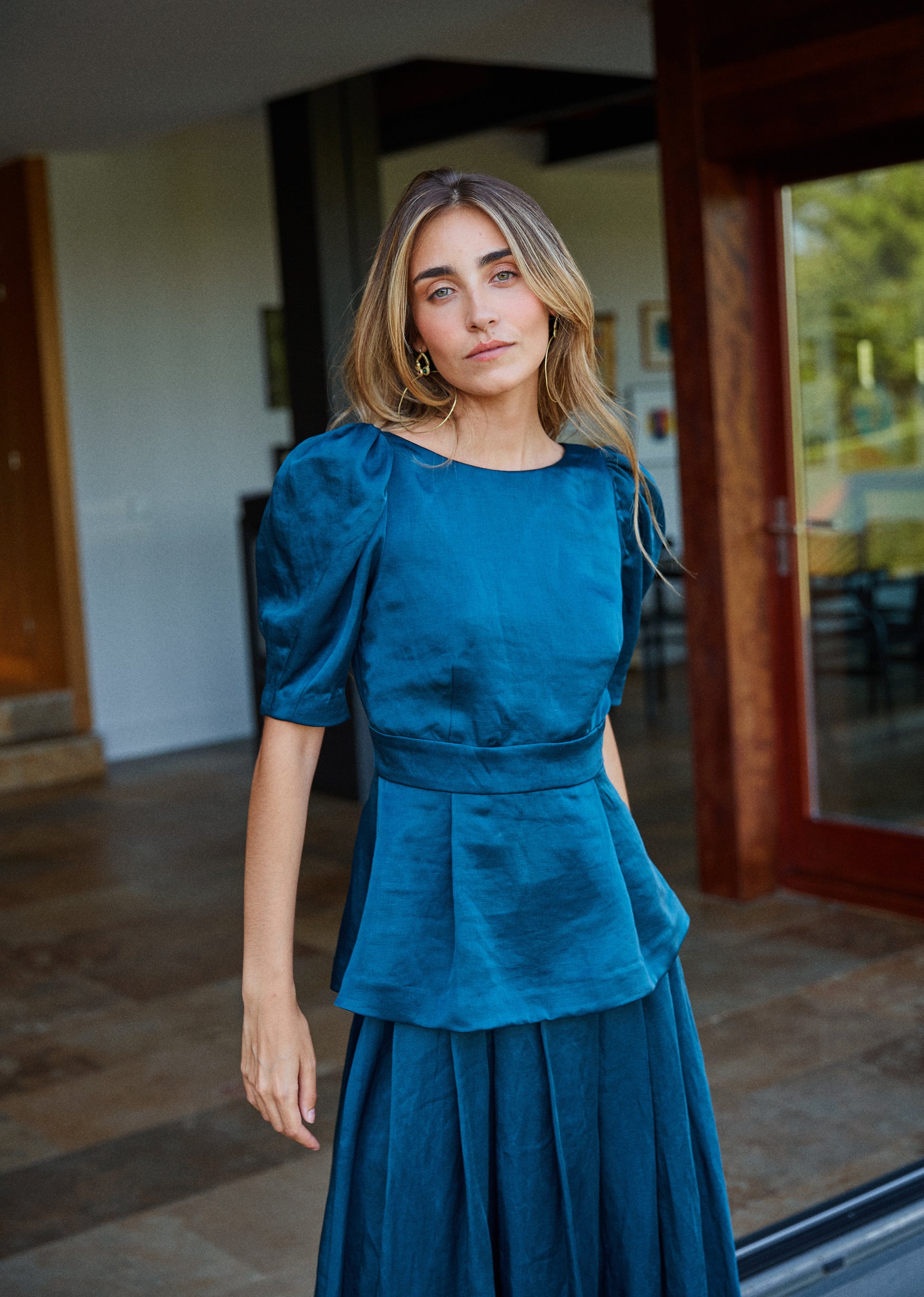 Top azul petróleo con mangas abullonadas y escote en pico, vista frontal, ideal para eventos elegantes.