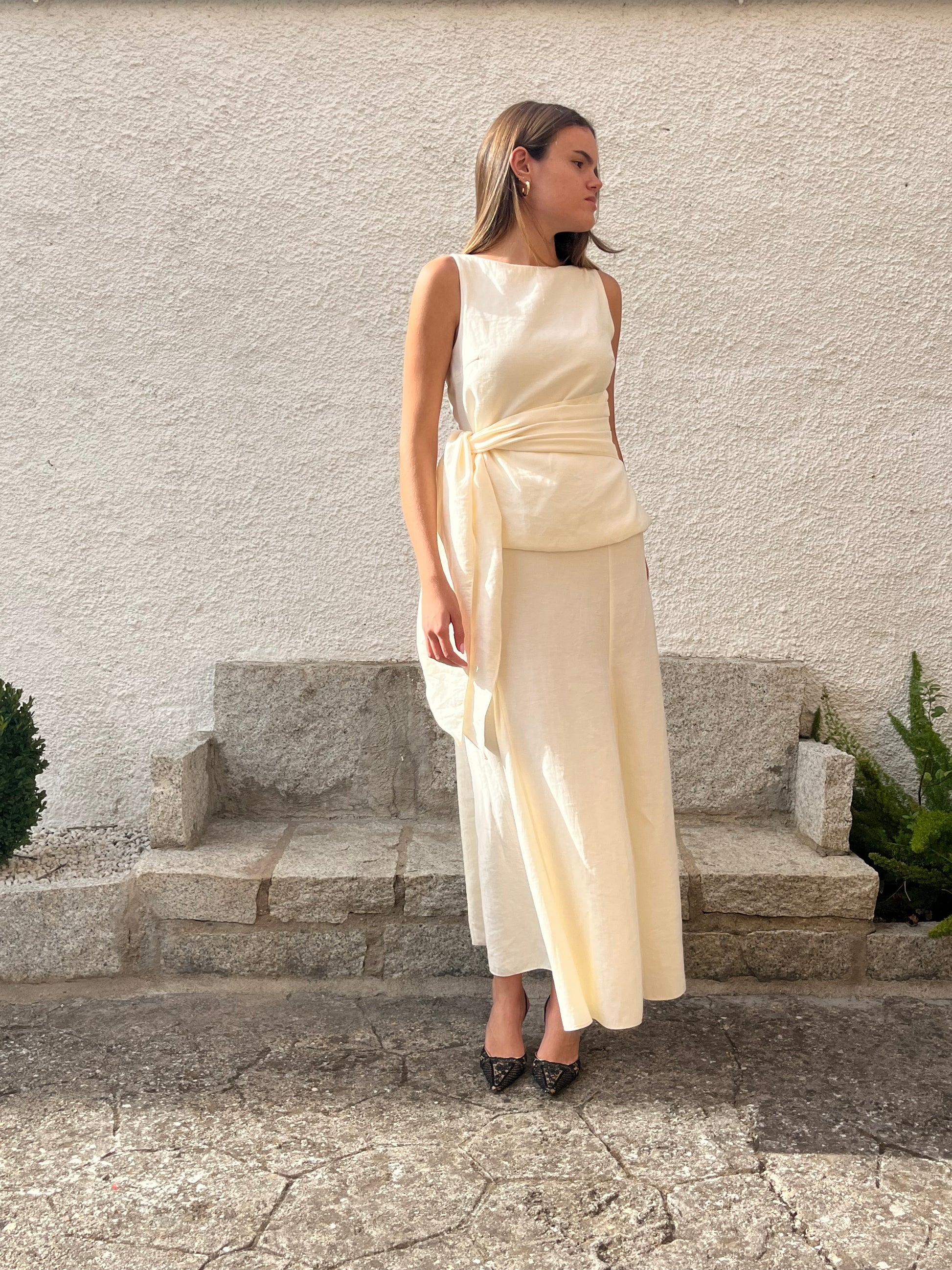 Conjunto blanco crudo de top con lazo y falda larga de godets, un outfit sofisticado para invitadas de boda o sesiones de preboda