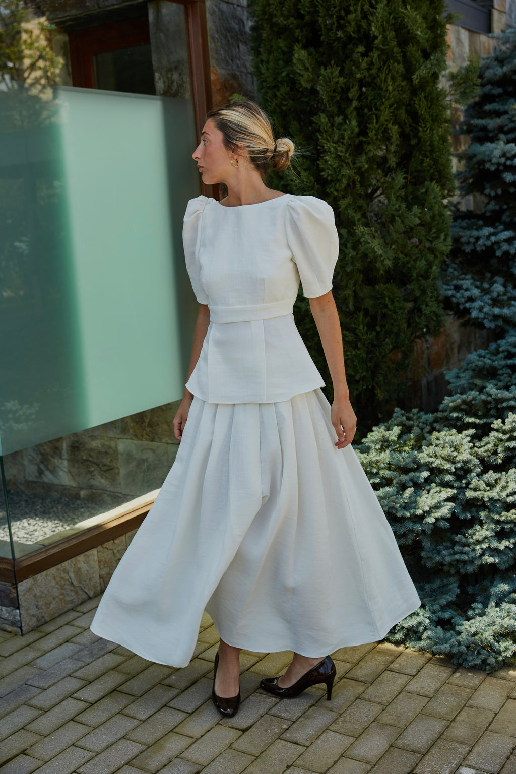 Top blanco con mangas voluminosas, vista lateral, conjunto de invitada.