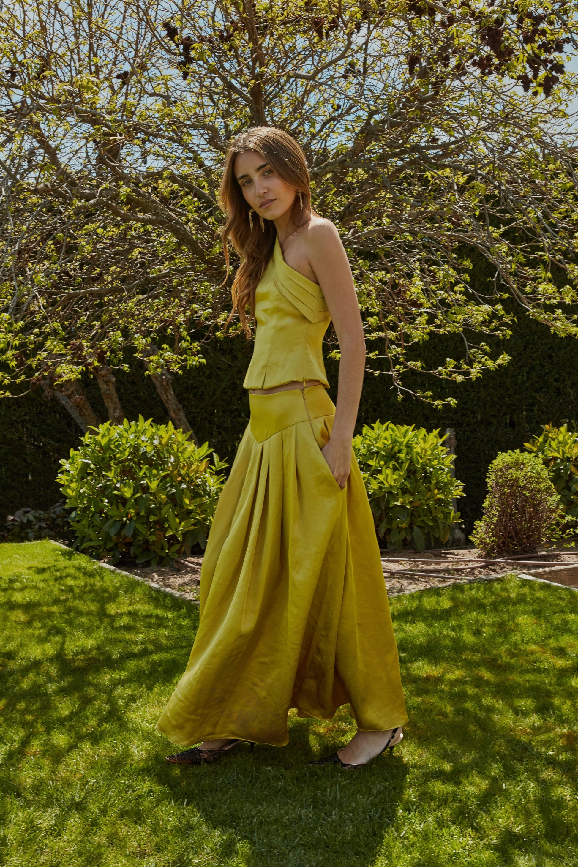 Conjunto elegante con top color aceite amarillo verde dorado plisado, vista lateral ideal para eventos.