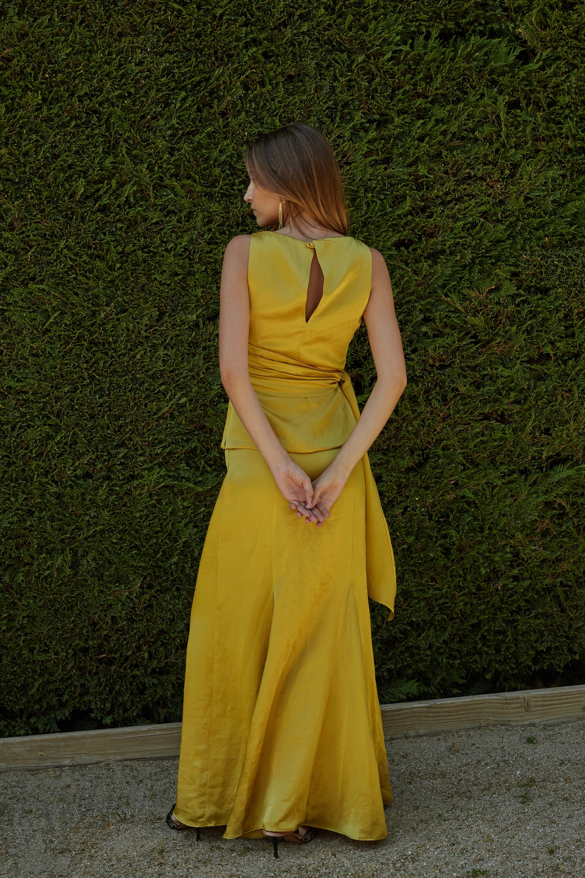 Vista trasera del top color aceite amarillo verde dorado con escote lágrima y cierre lateral invisible.