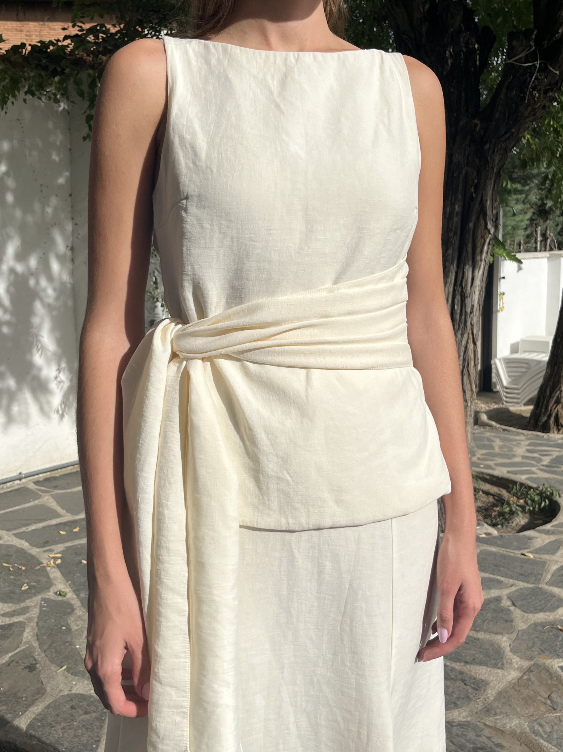  Detalle del top en blanco crudo con lazo en la cintura, un toque elegante y romántico para bodas o prebodas