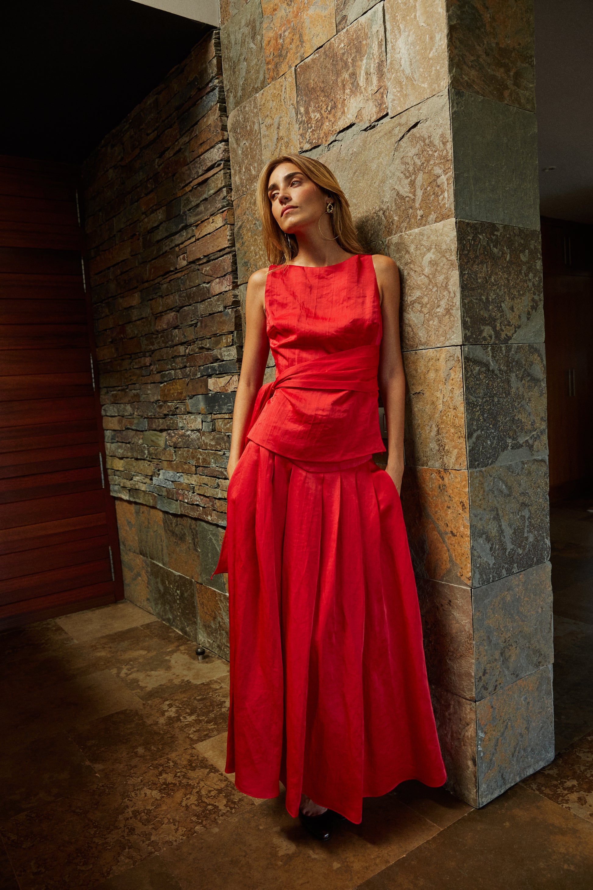 Top rojo con lazo combinado con falda de tablas, outfit sofisticado para invitada de evento.