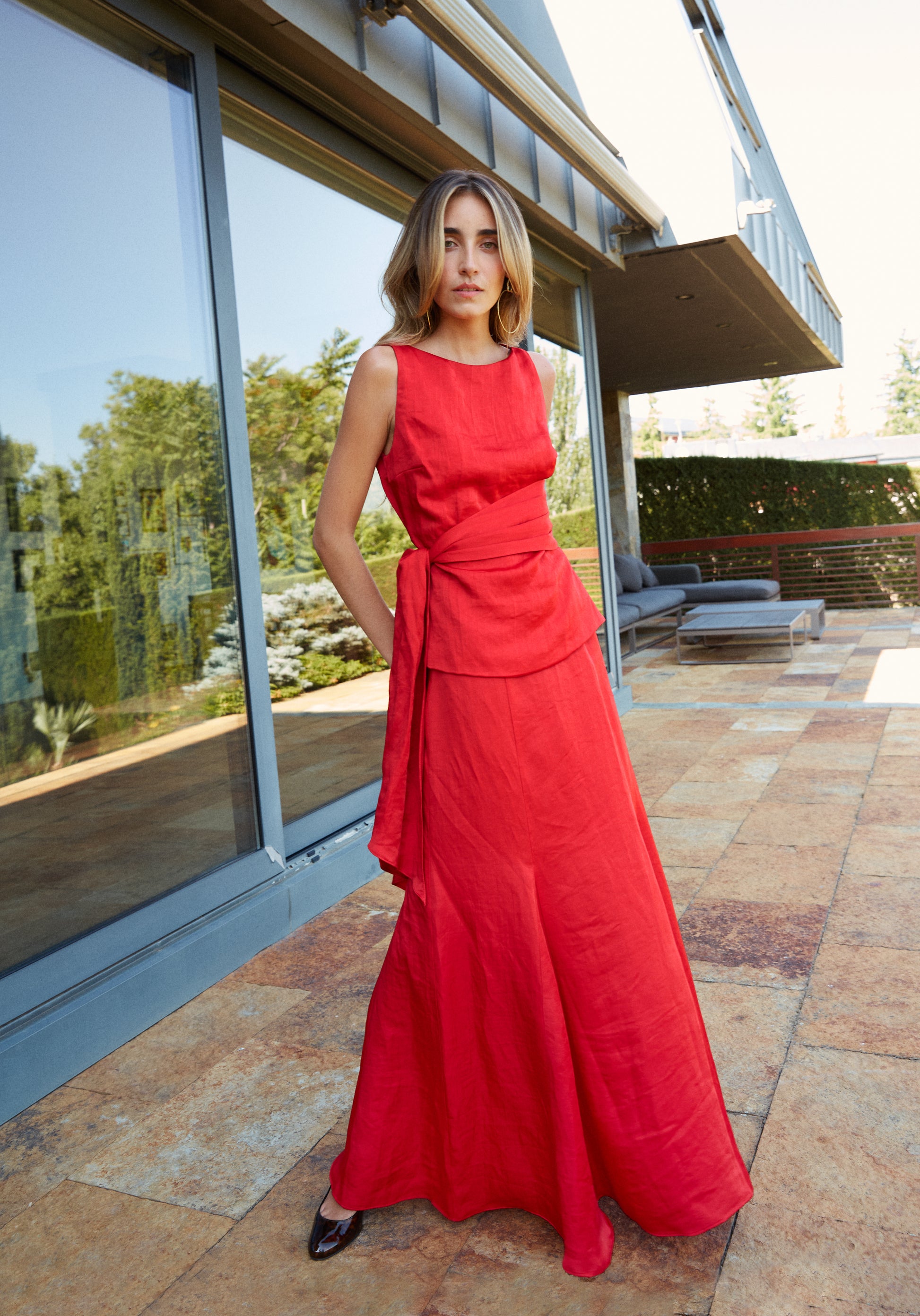 Conjunto elegante de top rojo con lazo y falda larga con godets, perfecto para eventos.
