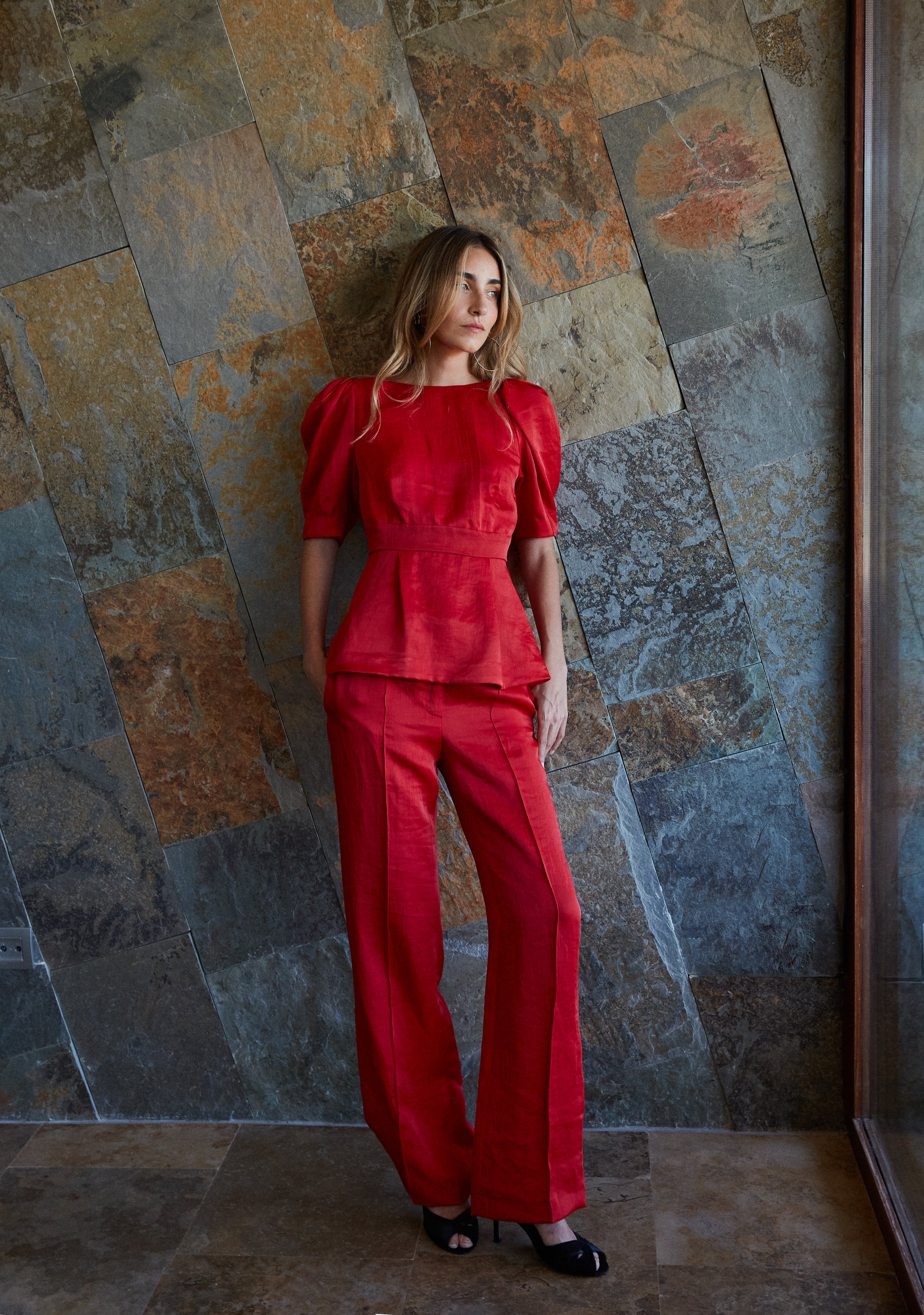 Top rojo con mangas voluminosas combinado con pantalón elegante, conjunto de invitada.